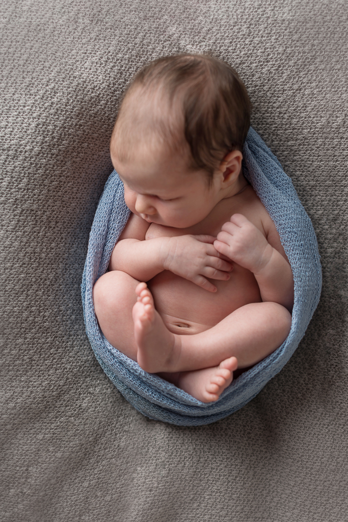 Rücken liegend in einen Wrap eingekuschelt Neugeborenenfotografie Eberdingen Pforzheim