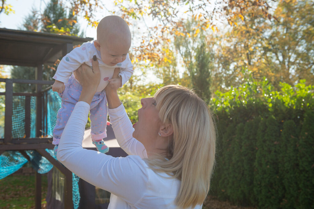 Mutter lässt Tochter in die Luft fliegen, fröhlicher Moment, Outdoor Familienfotografie Gegenlicht Bietigheim