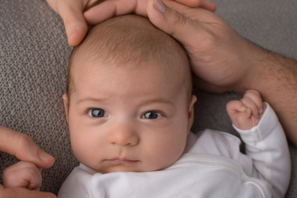 Baby schaut neugierig in die Kamera – Babyfotoshooting Ludwigsburg