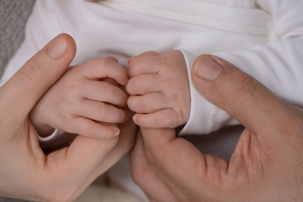 Eltern halten zärtlich die kleinen Hände ihres Babys – Babyfotoshooting Ludwigsburg