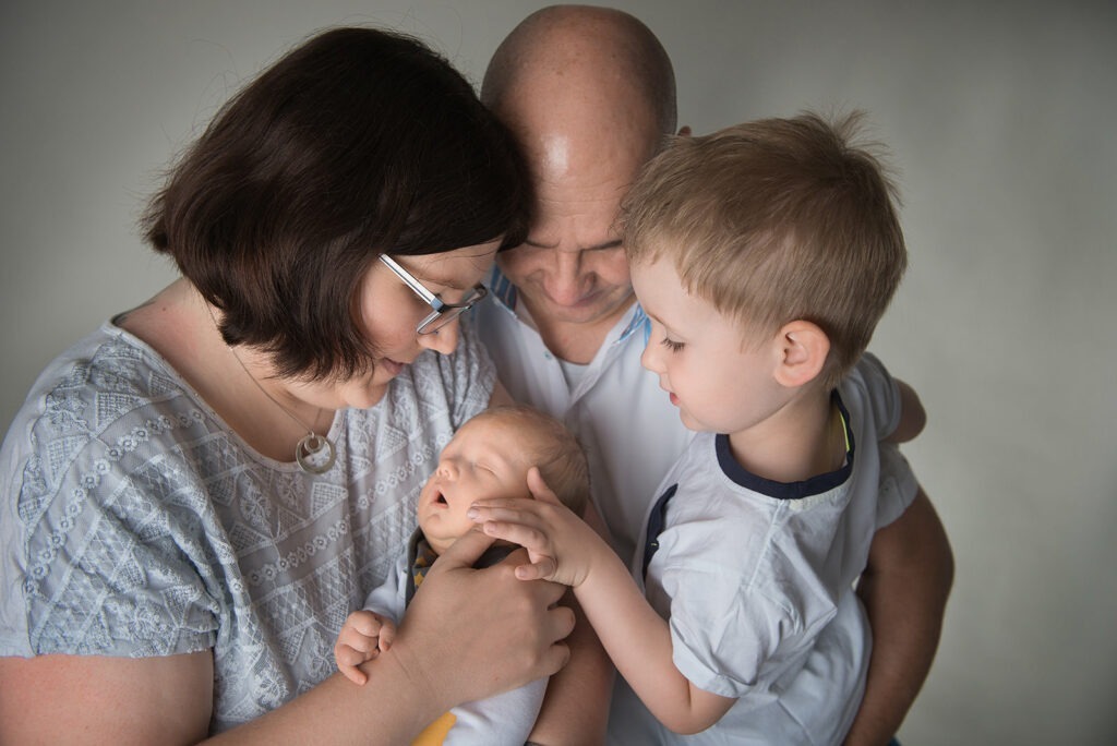 Familie bestaunt ihr neugeborenes Baby Babyfotograf Vaihingen Enz