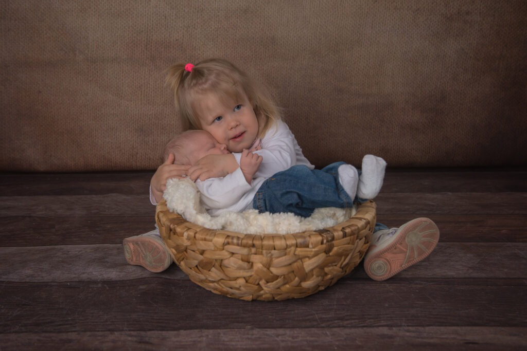 Die große Schwester umarmt sein Geschwisterchen Newborn Shooting Ludwigsburg