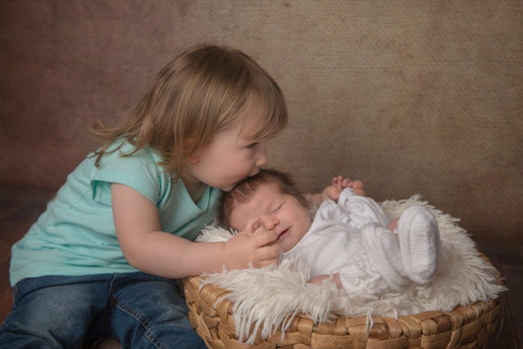Die Große Schwester küsst sein Geschwisterchen Baby Fotograf Bietigheim