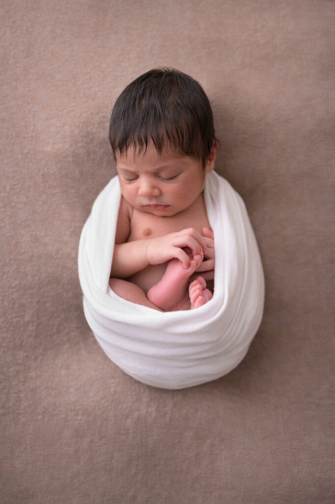 Neugeborenes eingewickelt auf Decke