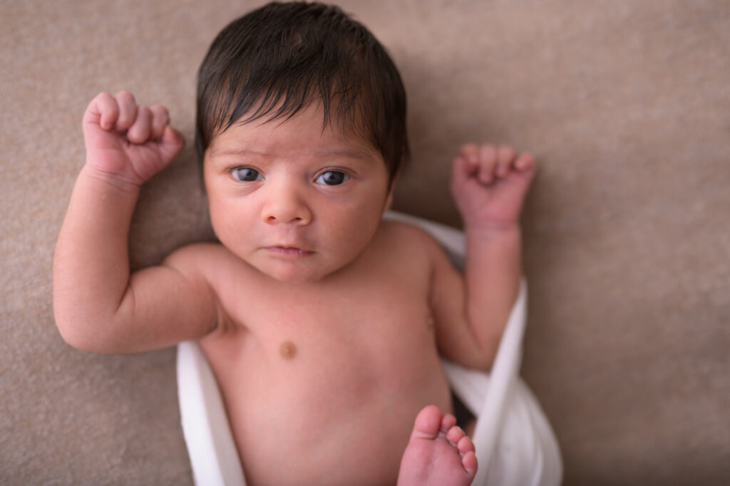 Baby mit offenen Augen beim Neugeborenenshooting