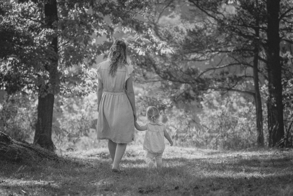 Mutter mit Tochter spazieren Rückansicht