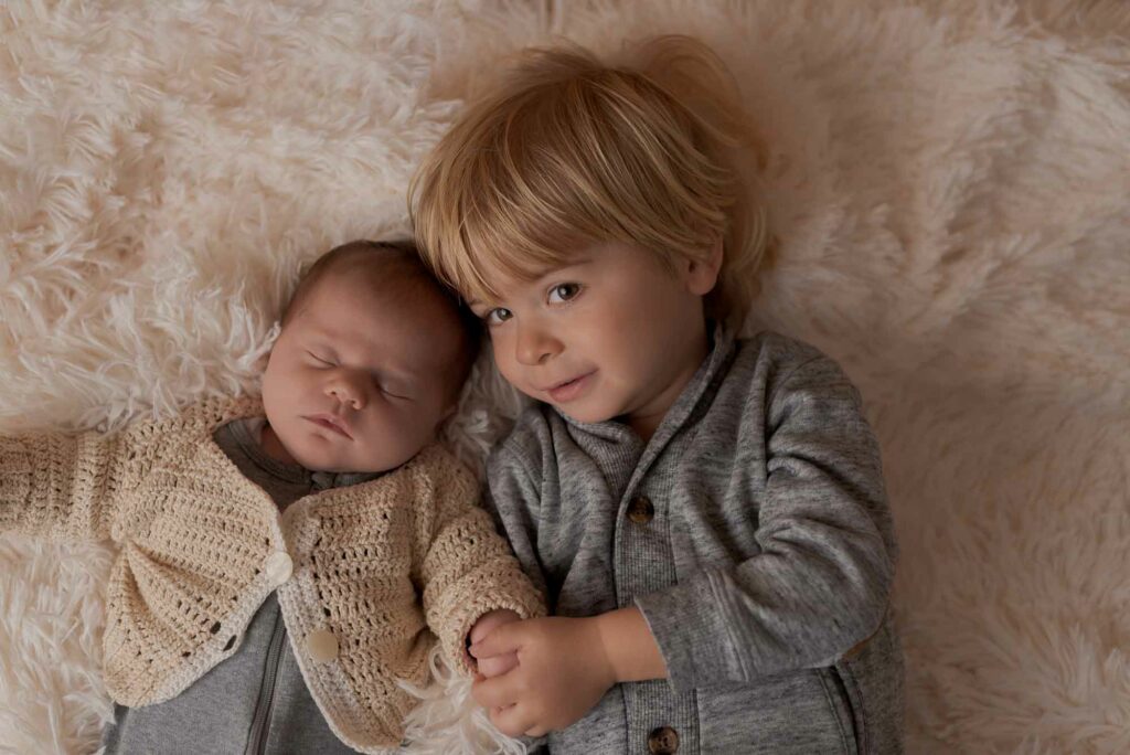 Babyfotos großer Bruder hat neugeborenen Baby im Arm