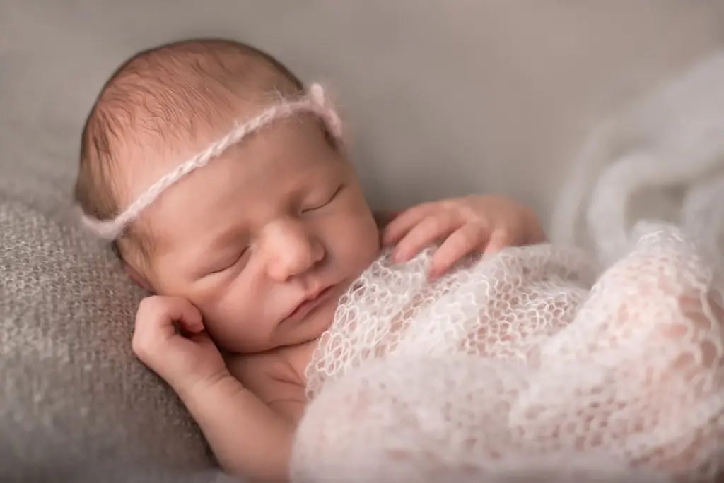 Neugeborenes Mädchen mit Haarband schlafend, zarte Neugeborenenfotos Eberdingen