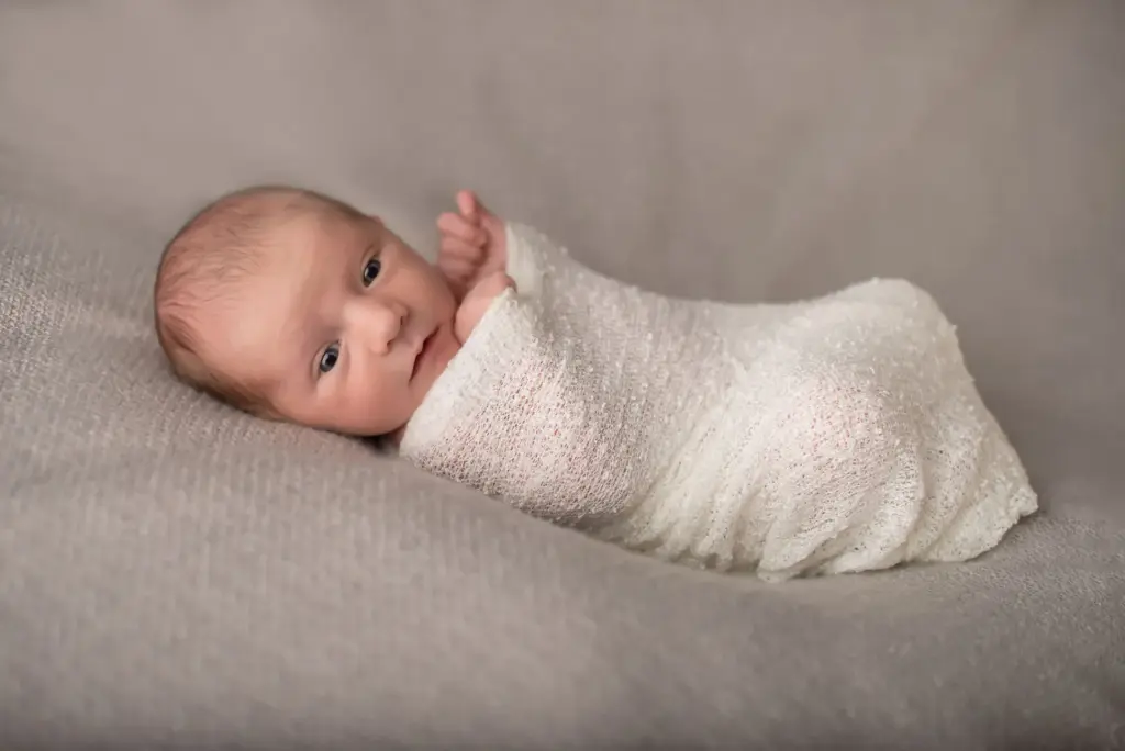 Eingewickeltes Neugeborenes von der Seite, Neugeborenenfotografin Eberdingen Studio