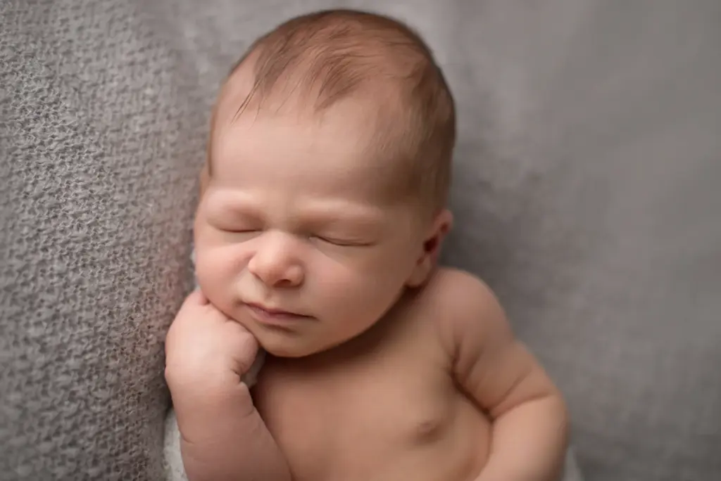 Neugeborener Nevio schlafend, Kopf auf die Hände gestützt – Newborn Fotoshooting Studio Ludwigsburg