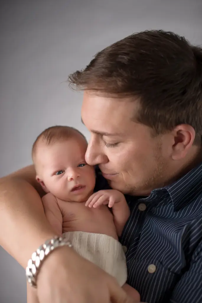 Papa hält wachen Nevio zärtlich in den Armen – Elternfotos beim Neugeborenen-Fotoshooting Hemmingen